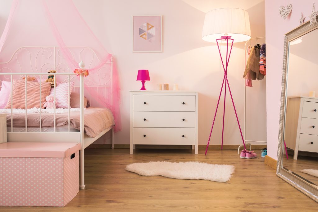 Commode et lit dans une chambre d'enfant avec lampe