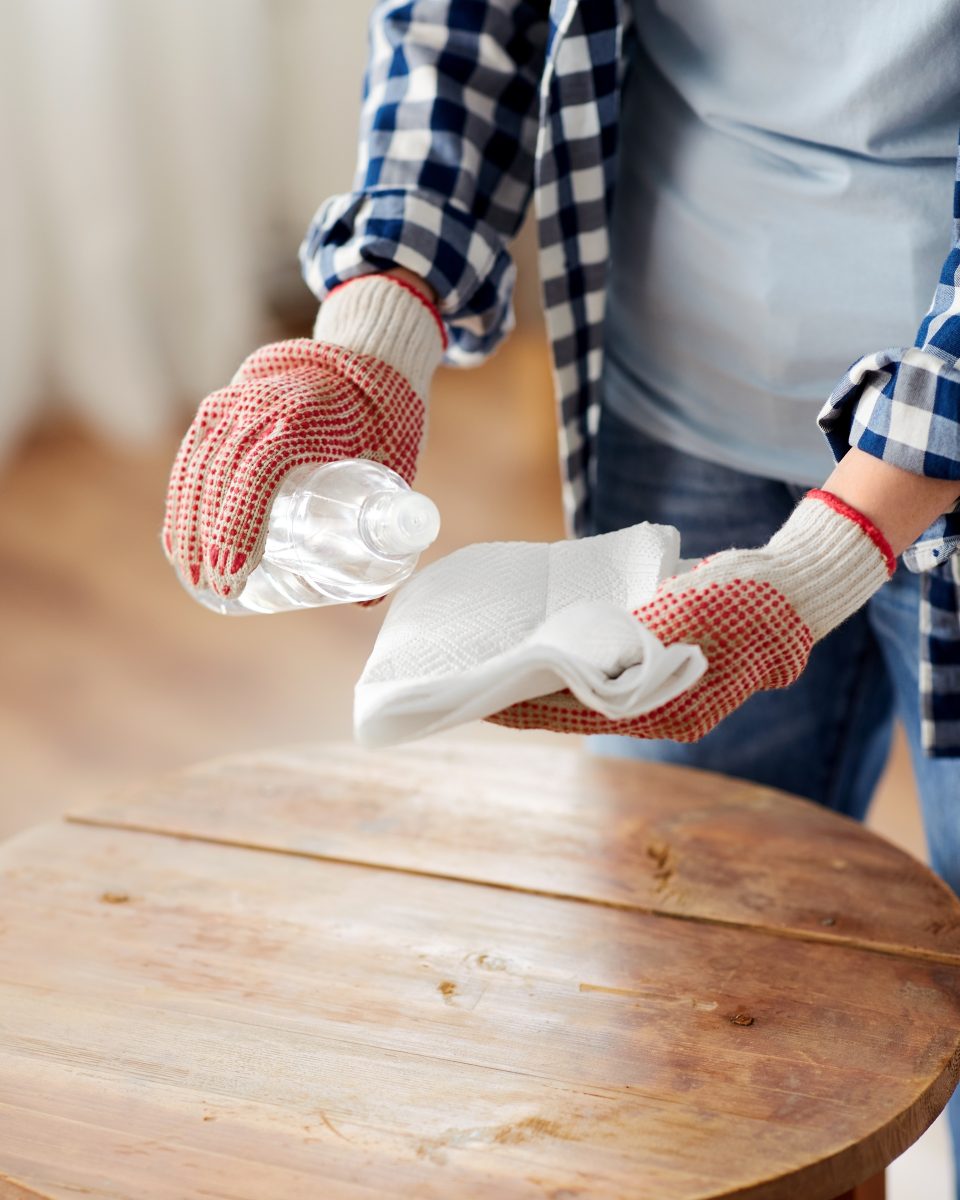 femme utilisant un chiffon microfibre sur une table en bois