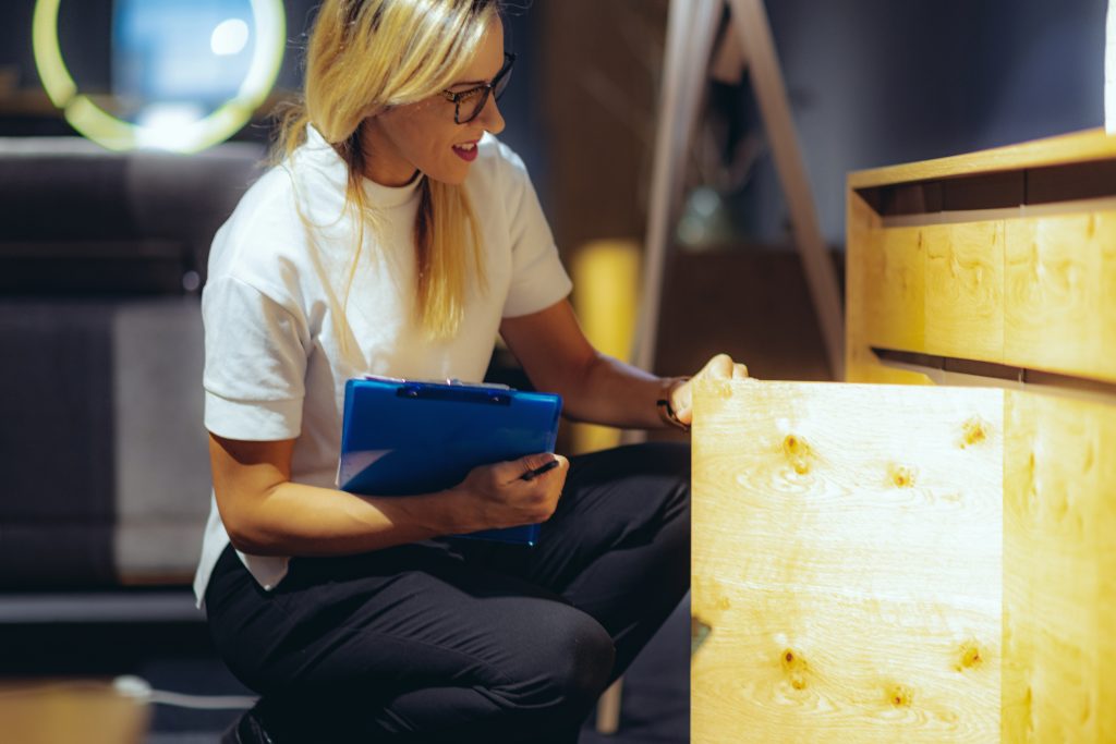 Professionnel examinant la valeur d'un meuble et faisant l'inventaire des biens mobiliers