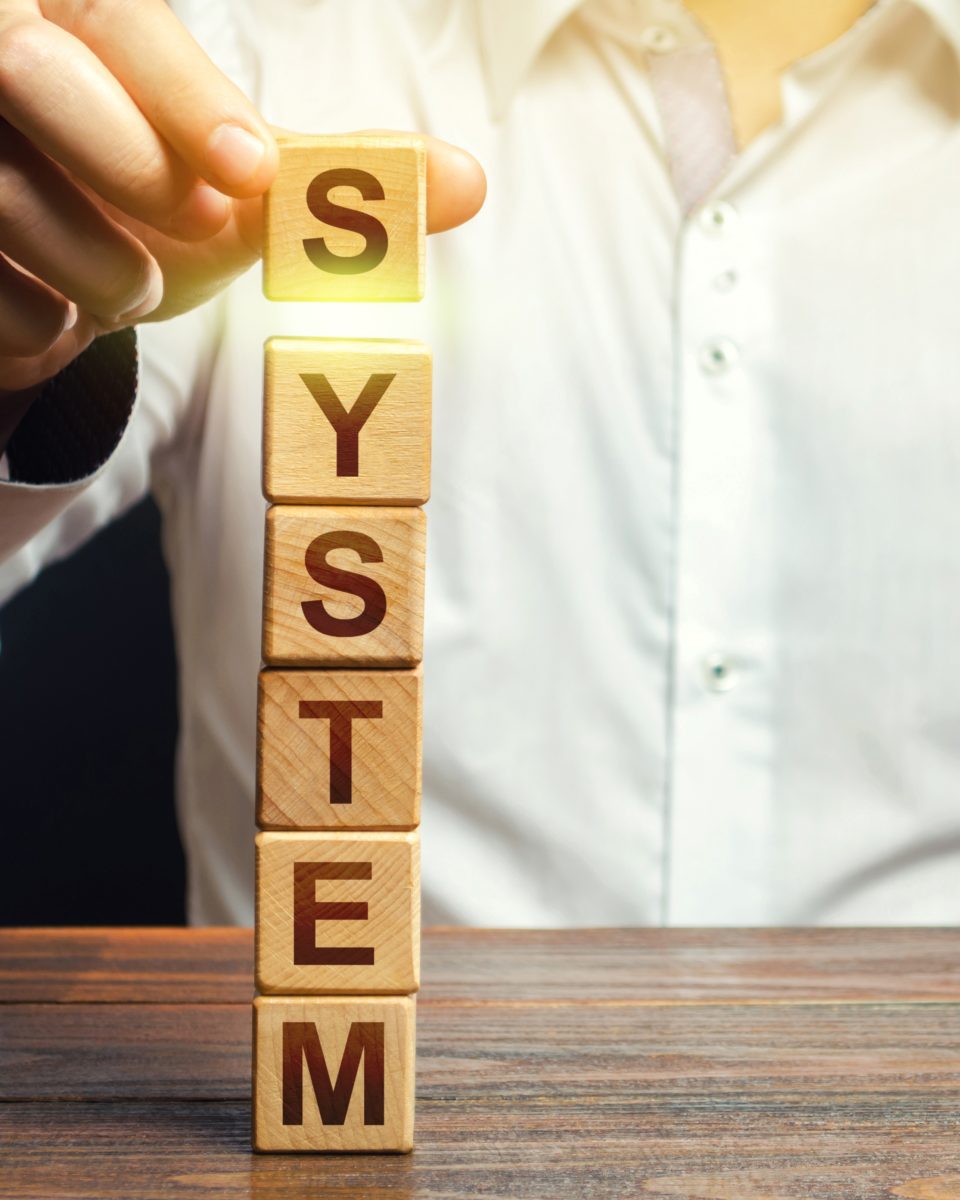 Un homme construisant une tour de blocs représentant un système organisé