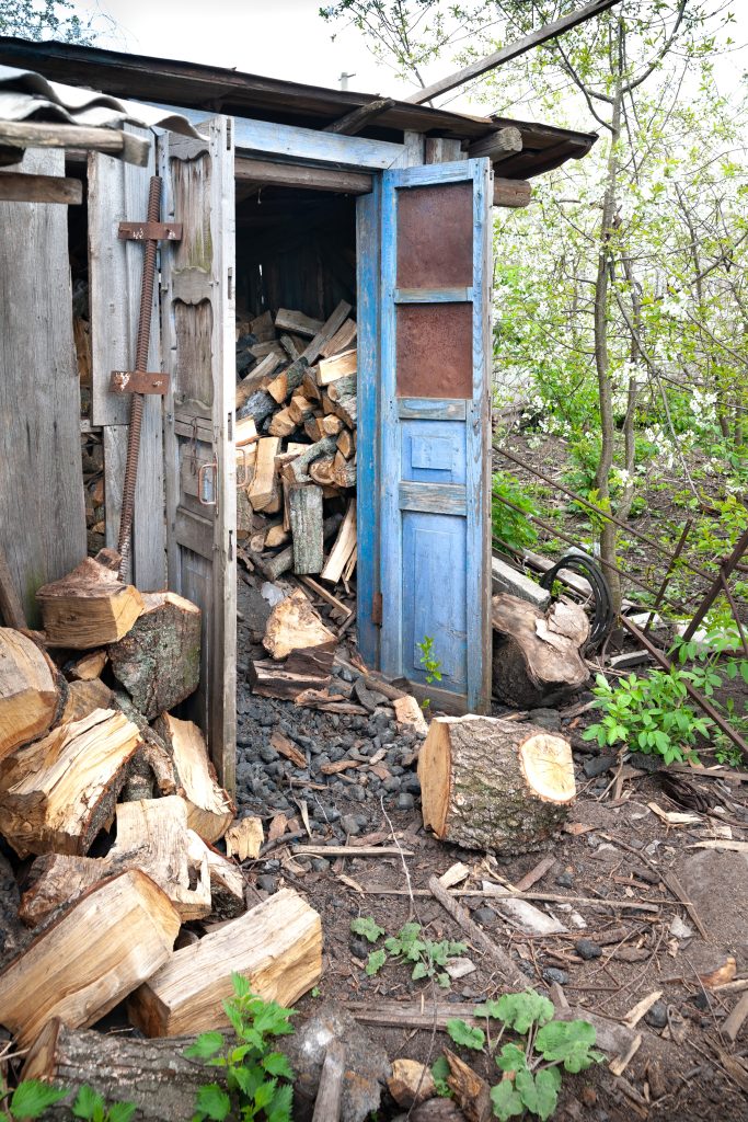 Un abri en bois rempli de bûches de bois empilées
